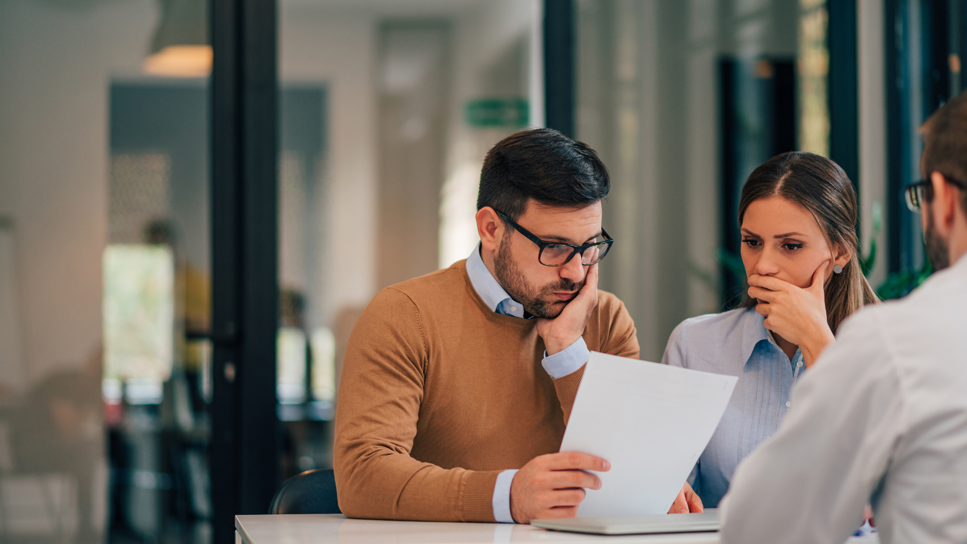 Three professionals reviewing documents in a modern office setting, illustrating collaboration and planning within a modern family office framework. Three professionals reviewing documents in a modern office setting, illustrating collaboration and planning within a modern family office framework.
