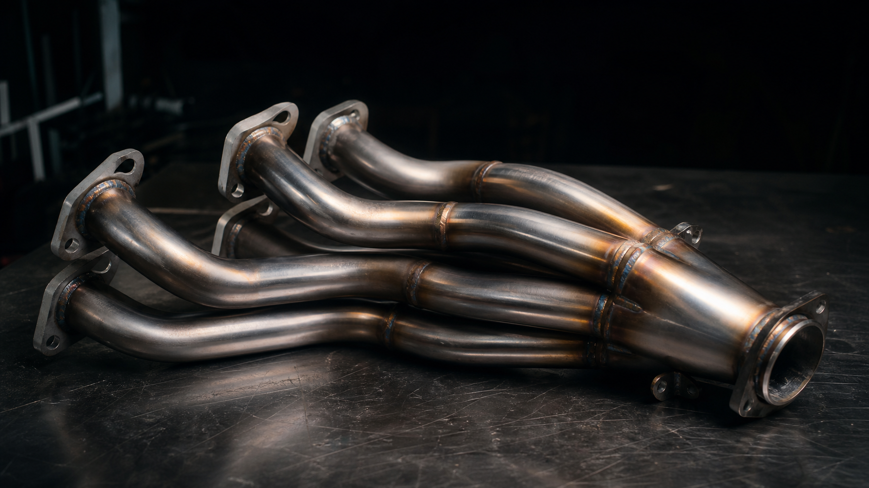 Equal-length stainless steel exhaust headers on workbench — exhaust and header installs Houston TX