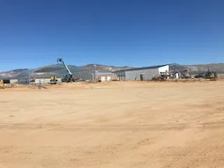 Custom steel building frame on an open site.
