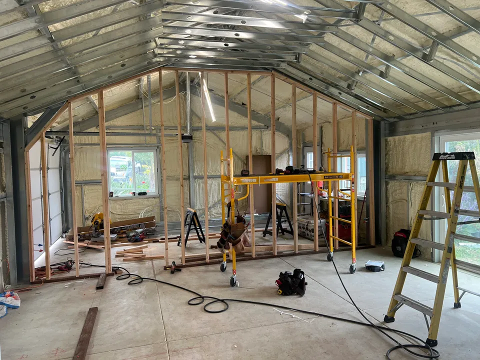 Insulated steel building interior with wood partitions under construction.
