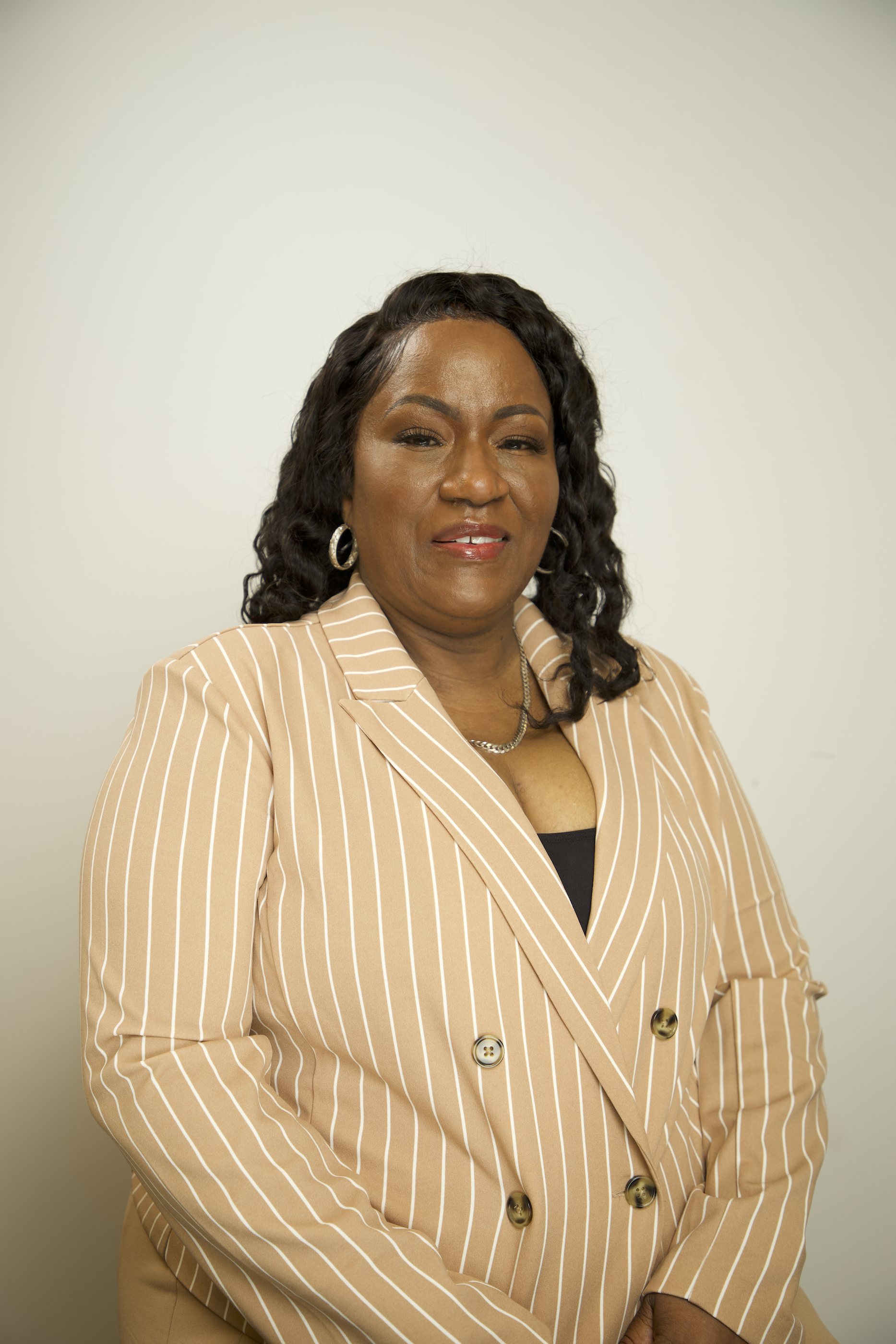Your Circle of Sisters tax professional, smiling in a tan pinstripe blazer