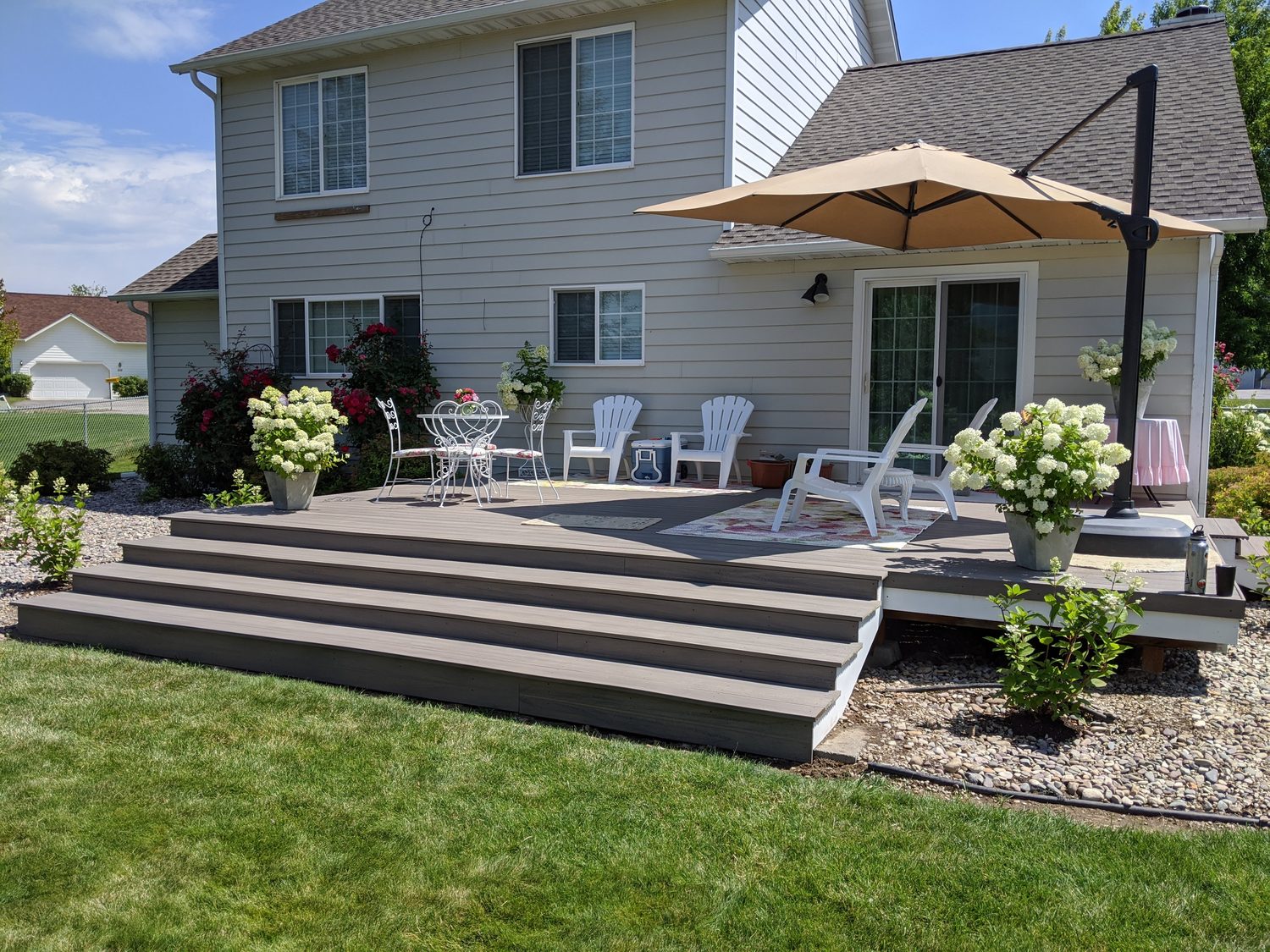 Multi-level gray composite deck with cascading steps and patio furniture