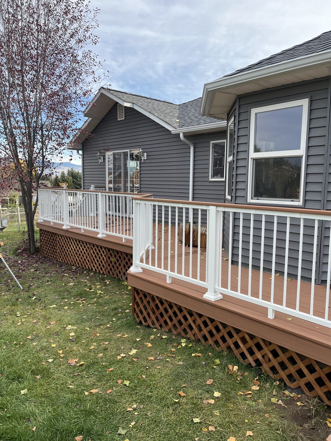 Raised deck with white railing and cedar lattice skirting