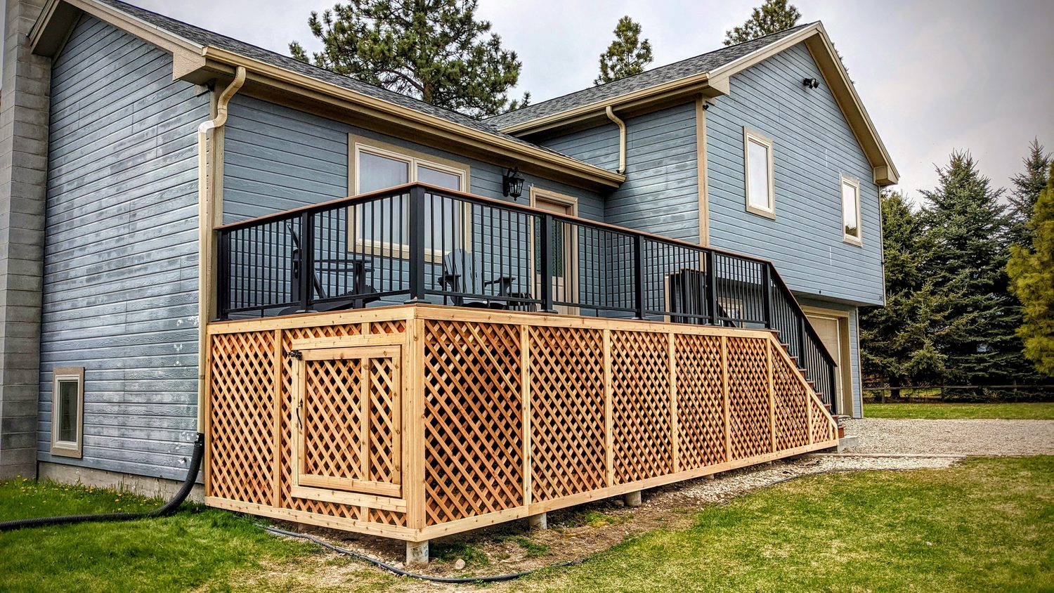 Raised deck with black metal balusters and cedar lattice skirting