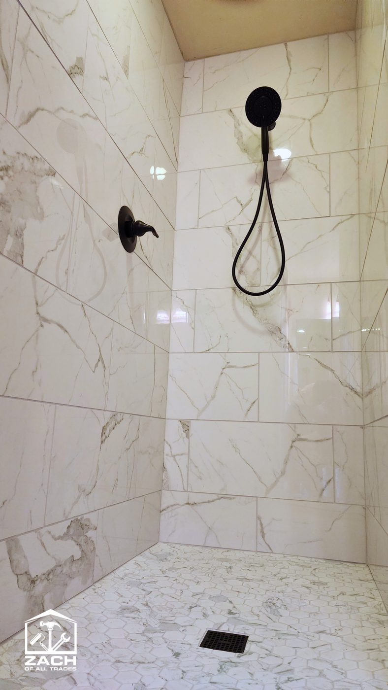 White Calacatta marble tile shower with matte-black fixtures