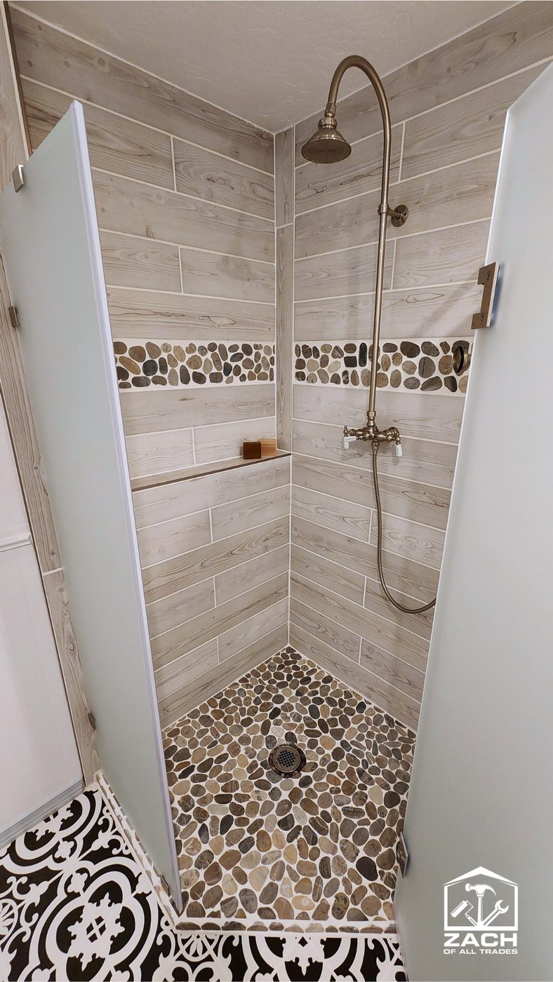 Wood-look plank tile shower with river-rock pebble floor