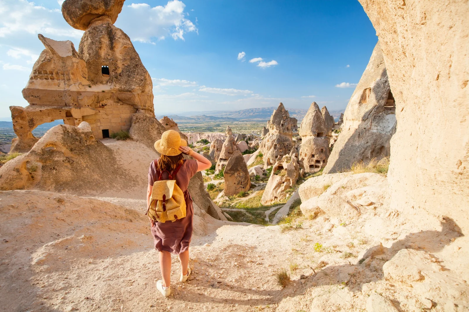 A traveler walking among Cappadocia’s rock dwellings