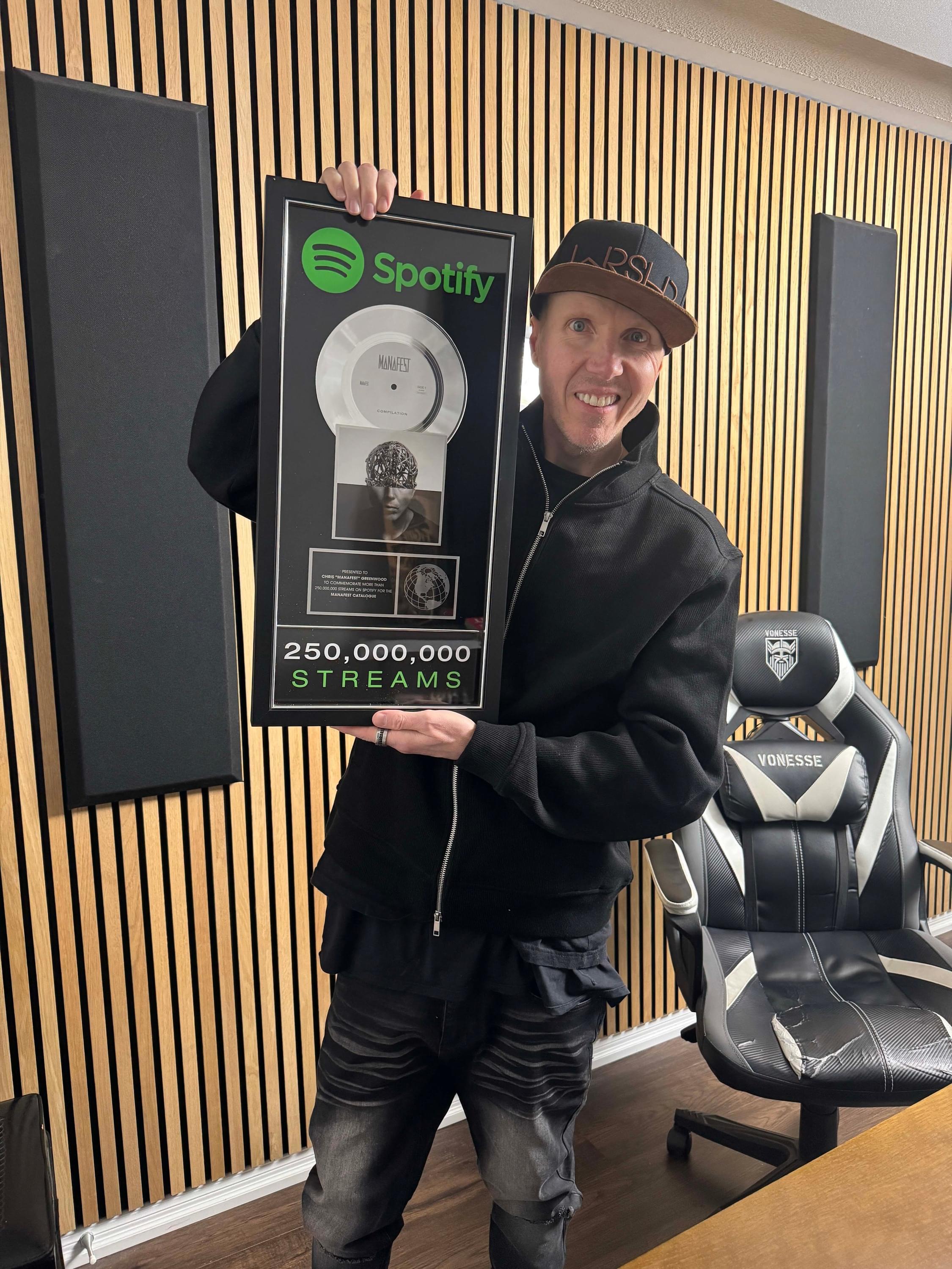 Manafest holding his 250 million streams plaque