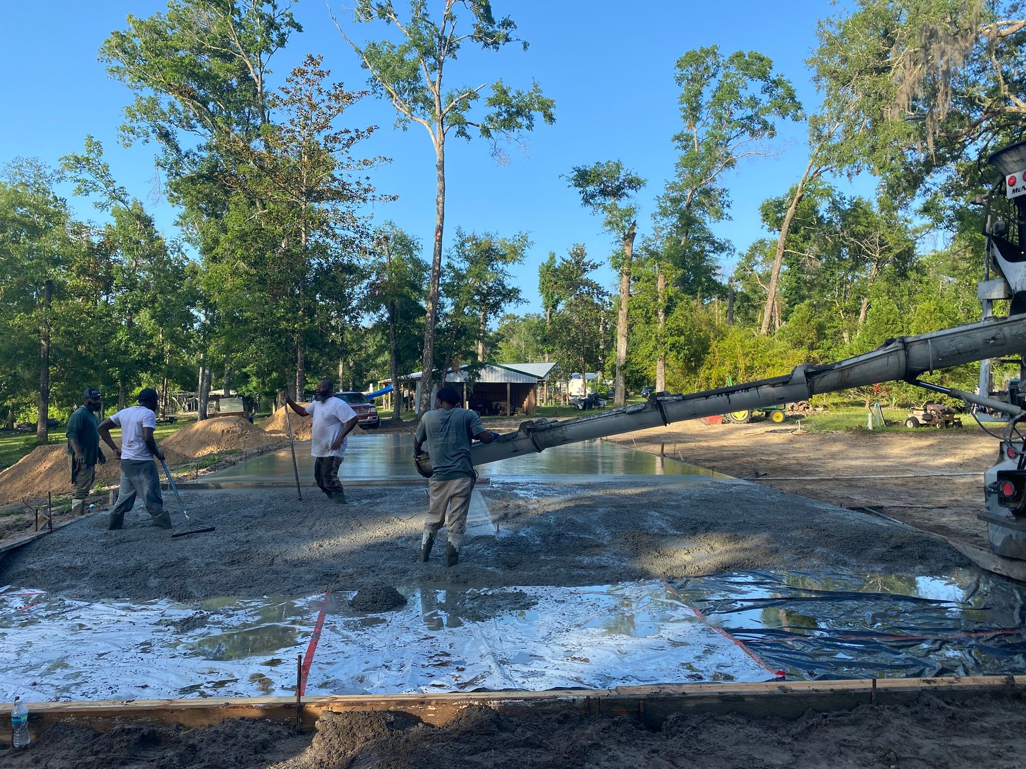 The James Reed Concrete crew guiding a pump truck chute into a fresh pour on a North Florida jobsite