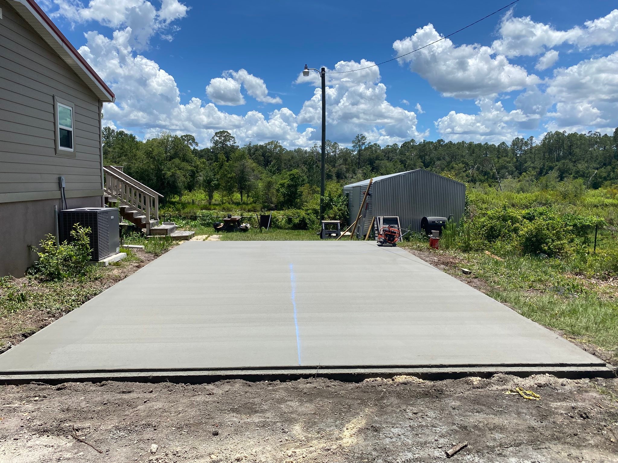 A finished concrete driveway poured by James Reed Concrete with a clean saw-cut joint running down the center