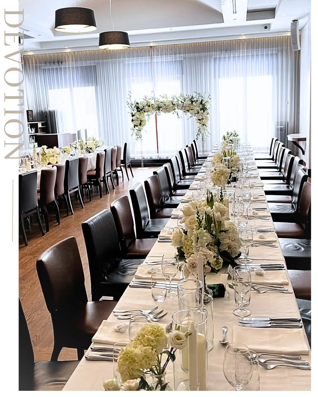 Long wedding head table with low white floral arrangements and candles in a modern Montreal reception venue