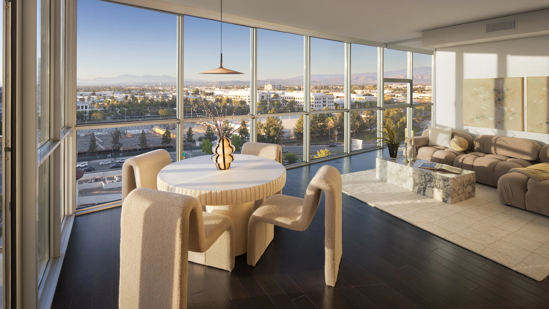 Skyline OC luxury dining area with panoramic corner windows overlooking Orange County cityscape at golden hour