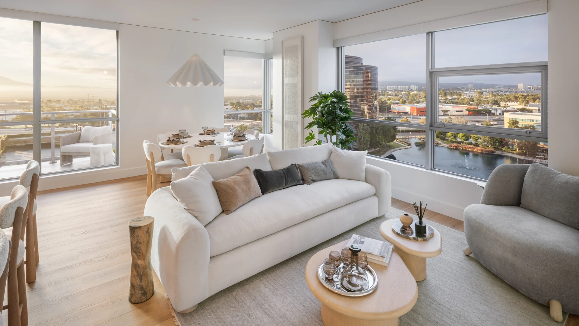 Skyline OC living room with terrace access, panoramic water and mountain views, and neutral luxury furnishings