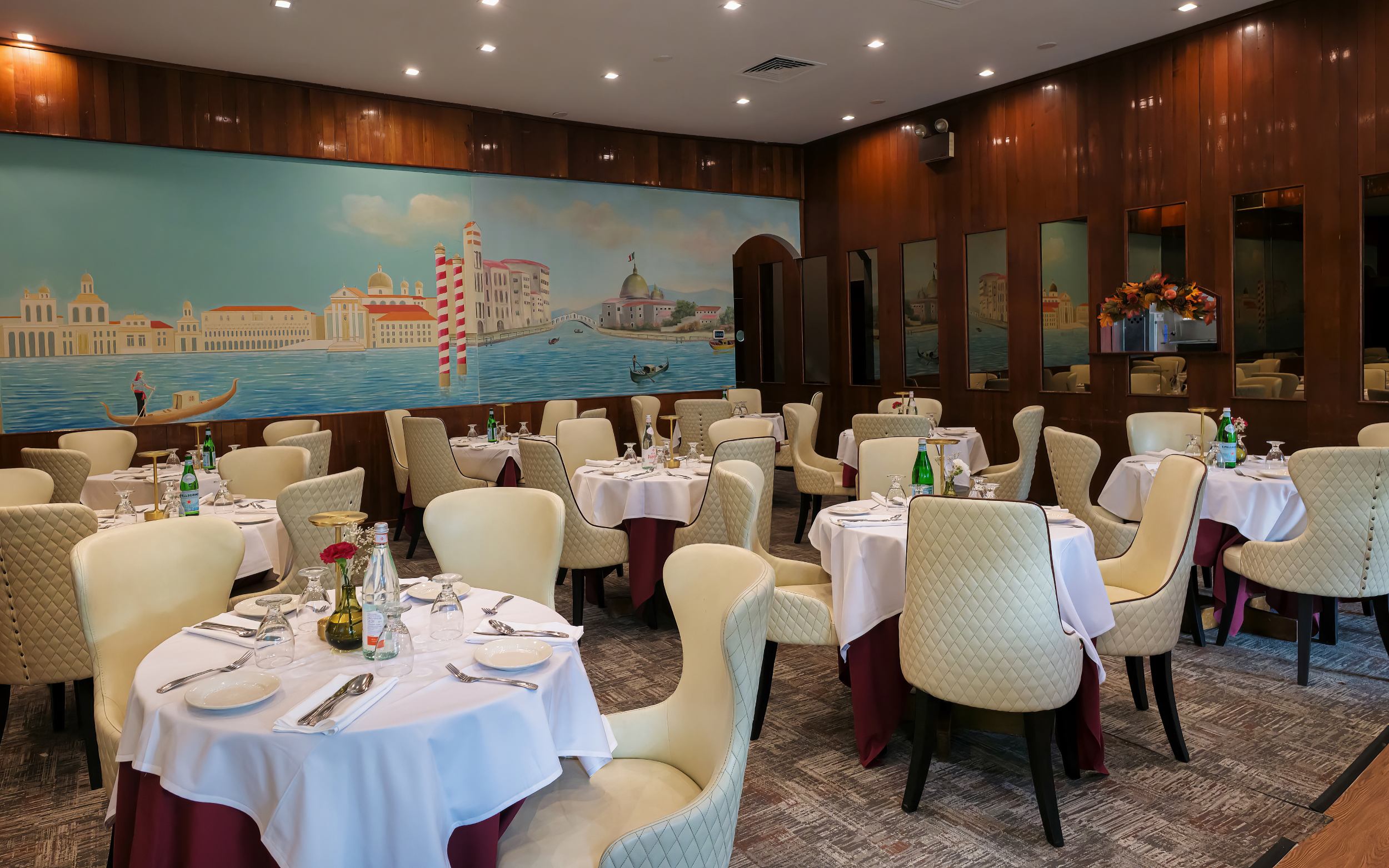 Portofino Ristorante dining room with set table and Italian coastal mural on Ascan Ave, Forest Hills