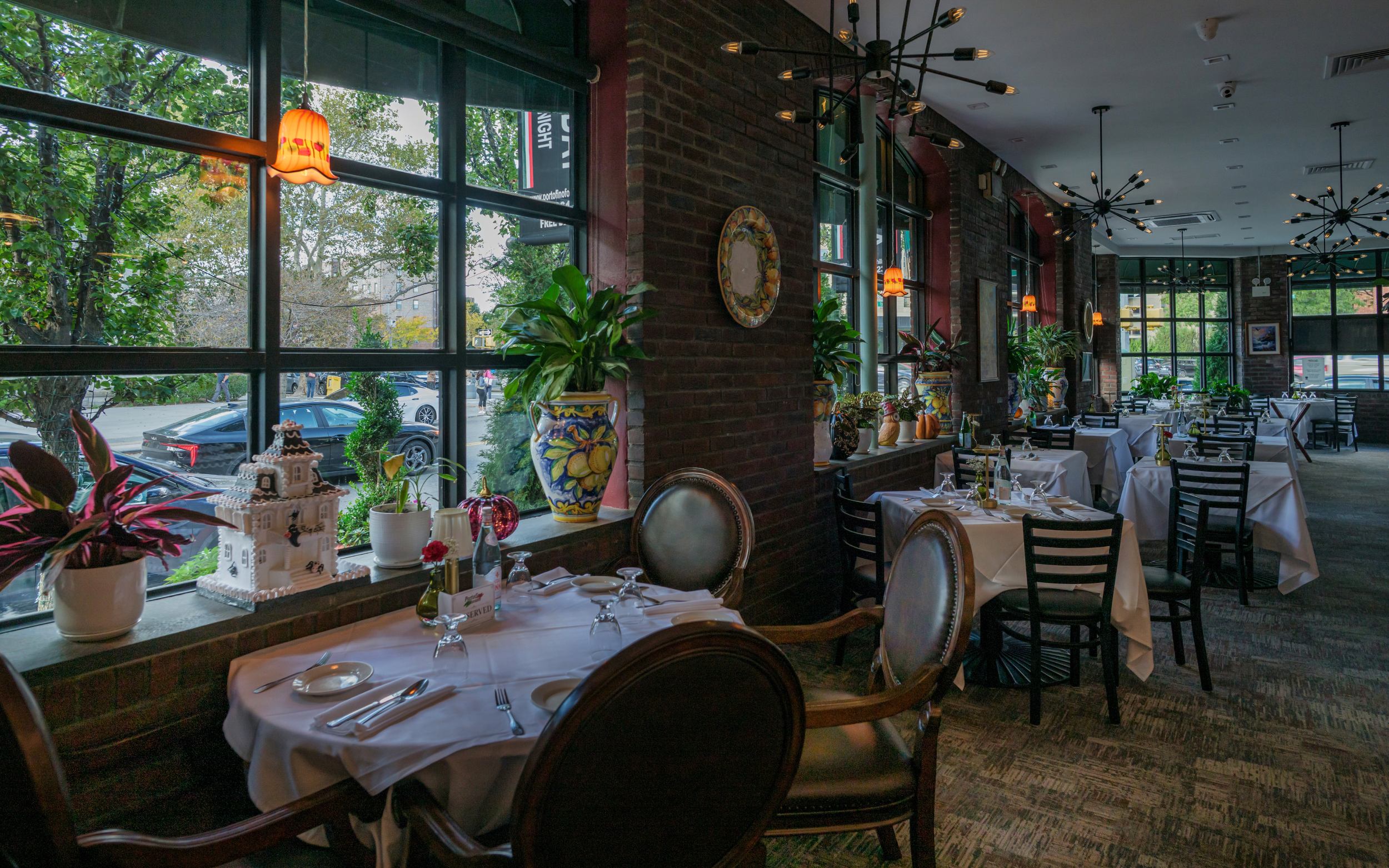 Brick-walled dining room with large windows at Portofino Forest Hills