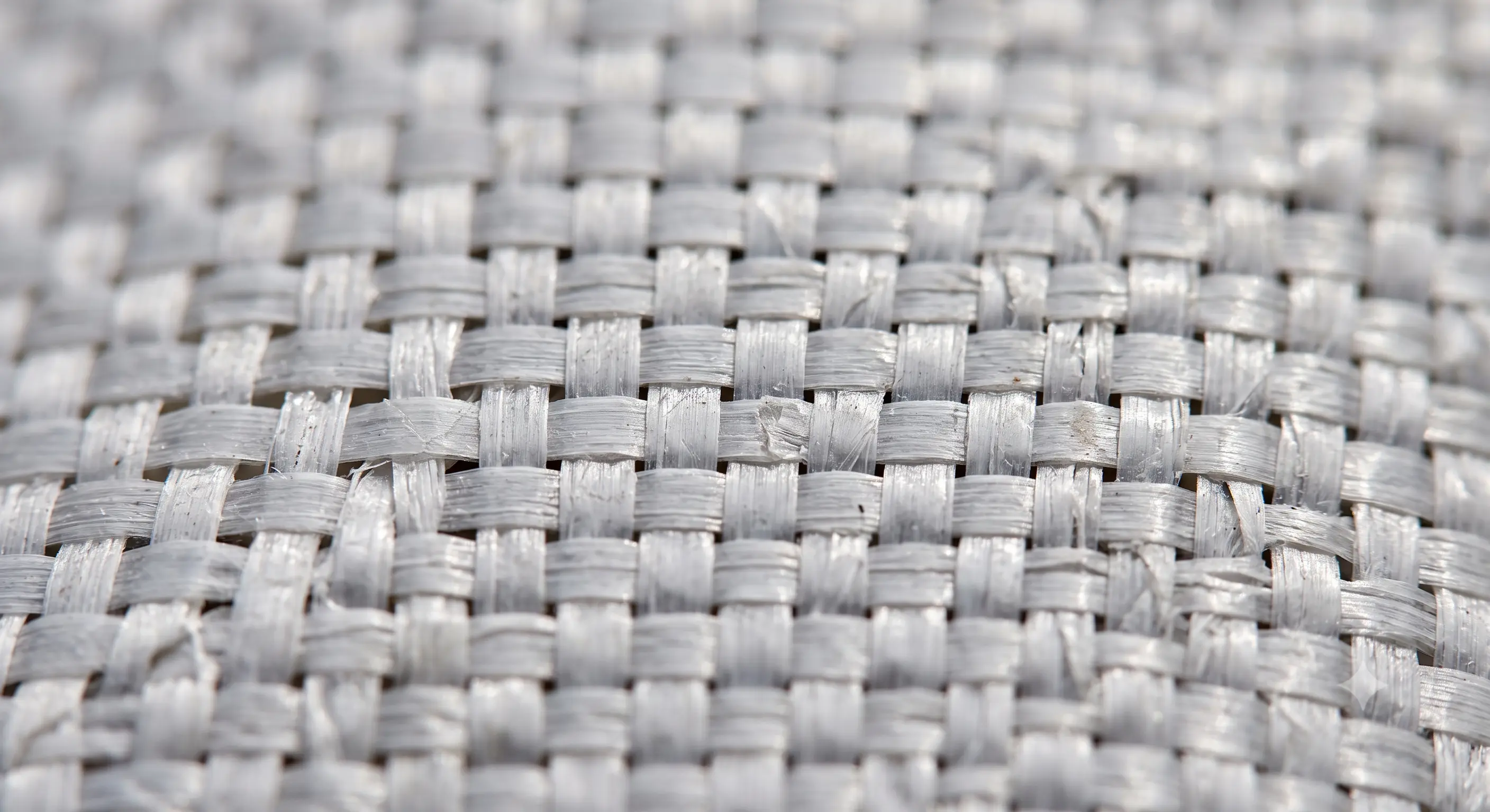 Close-up of woven house wrap showing the woven strip texture