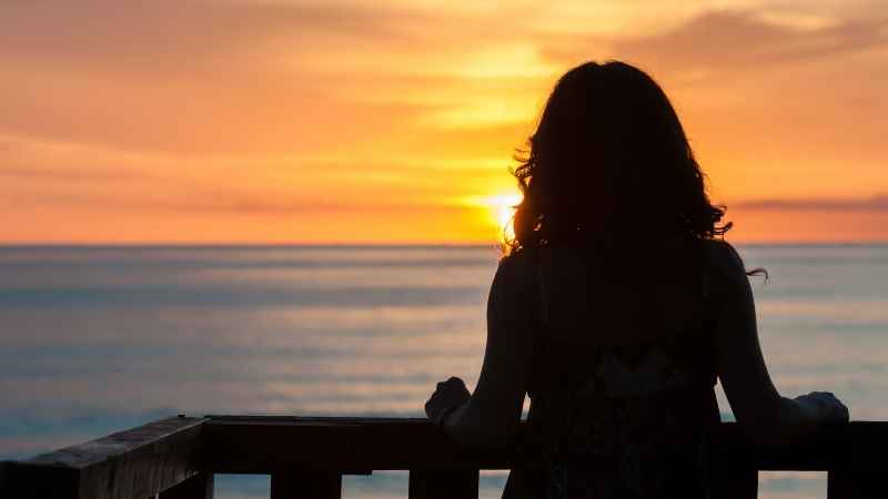 Woman contemplating as the sun rises on a new dawn