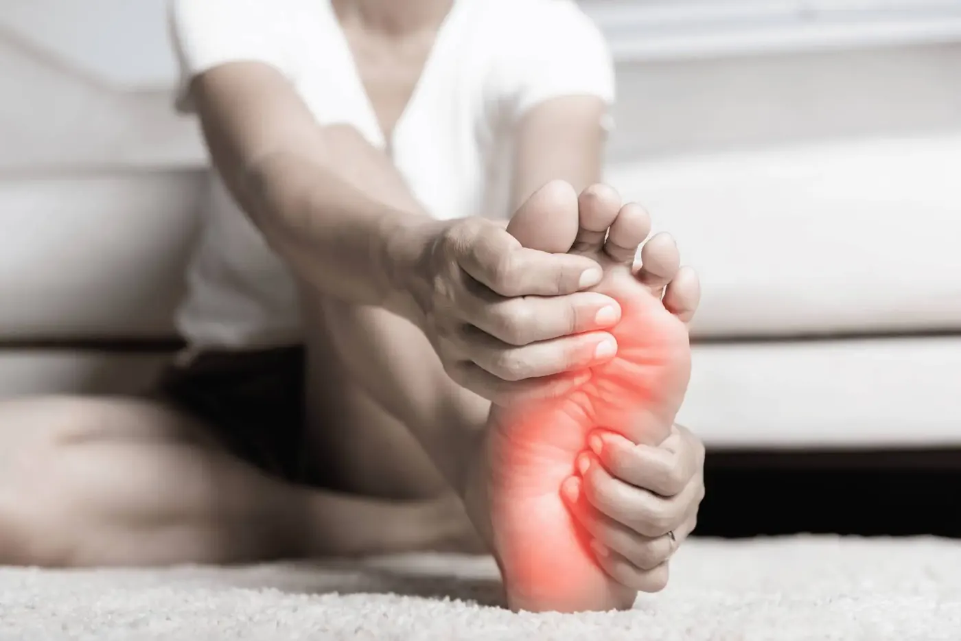 Hands holding a painful foot