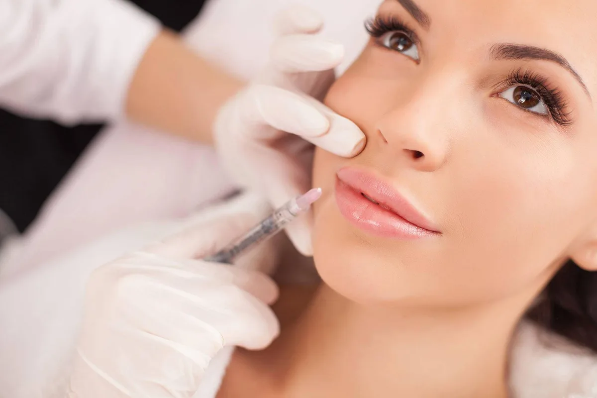 Woman receiving a lip filler injection