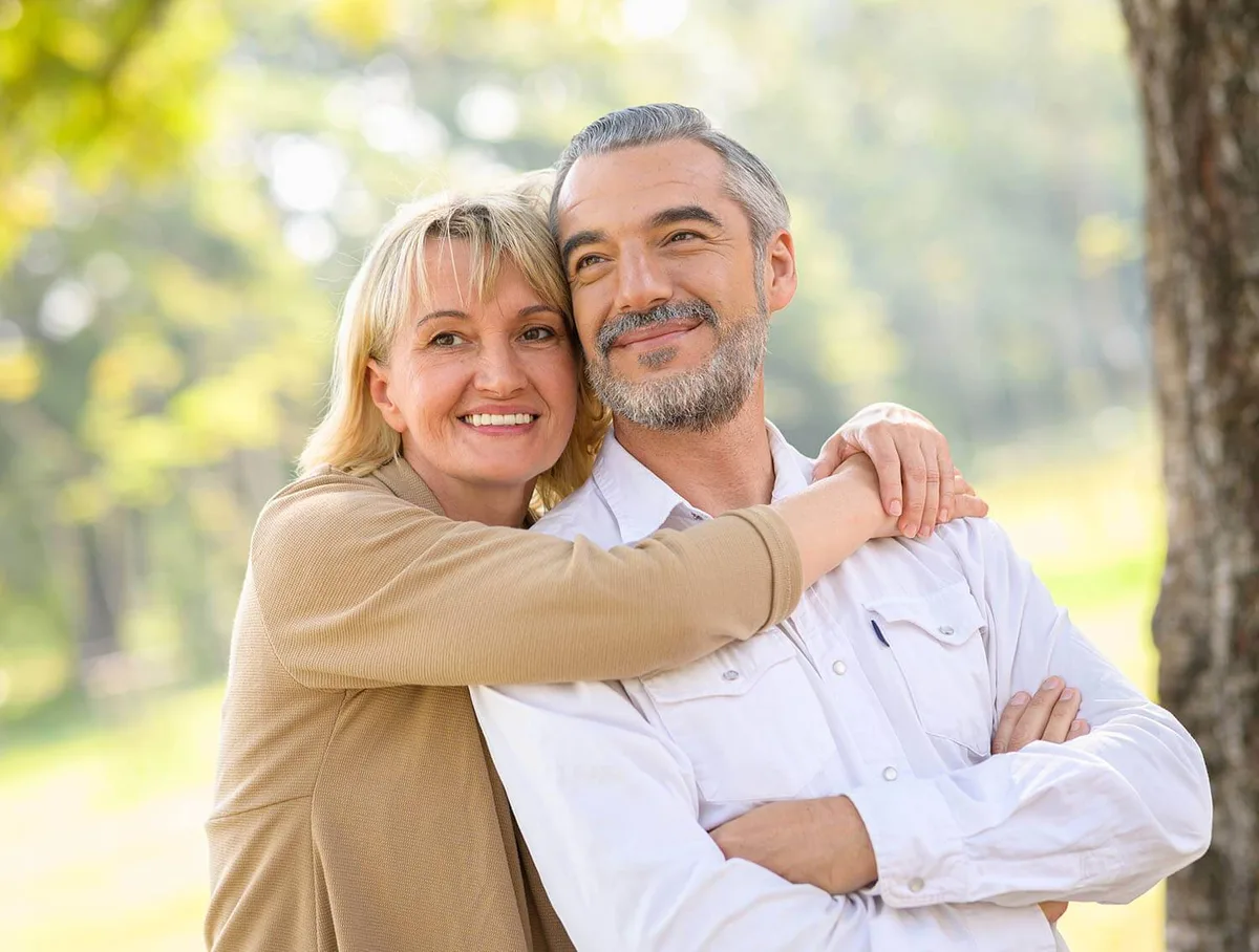 Couple in their fifties smiling outdoors
