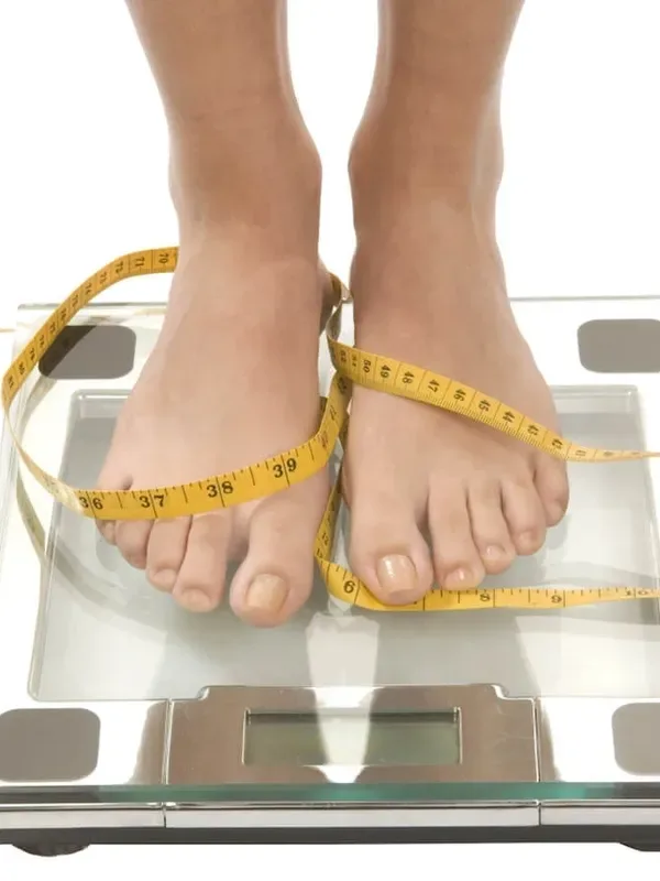 Feet on a scale with a measuring tape