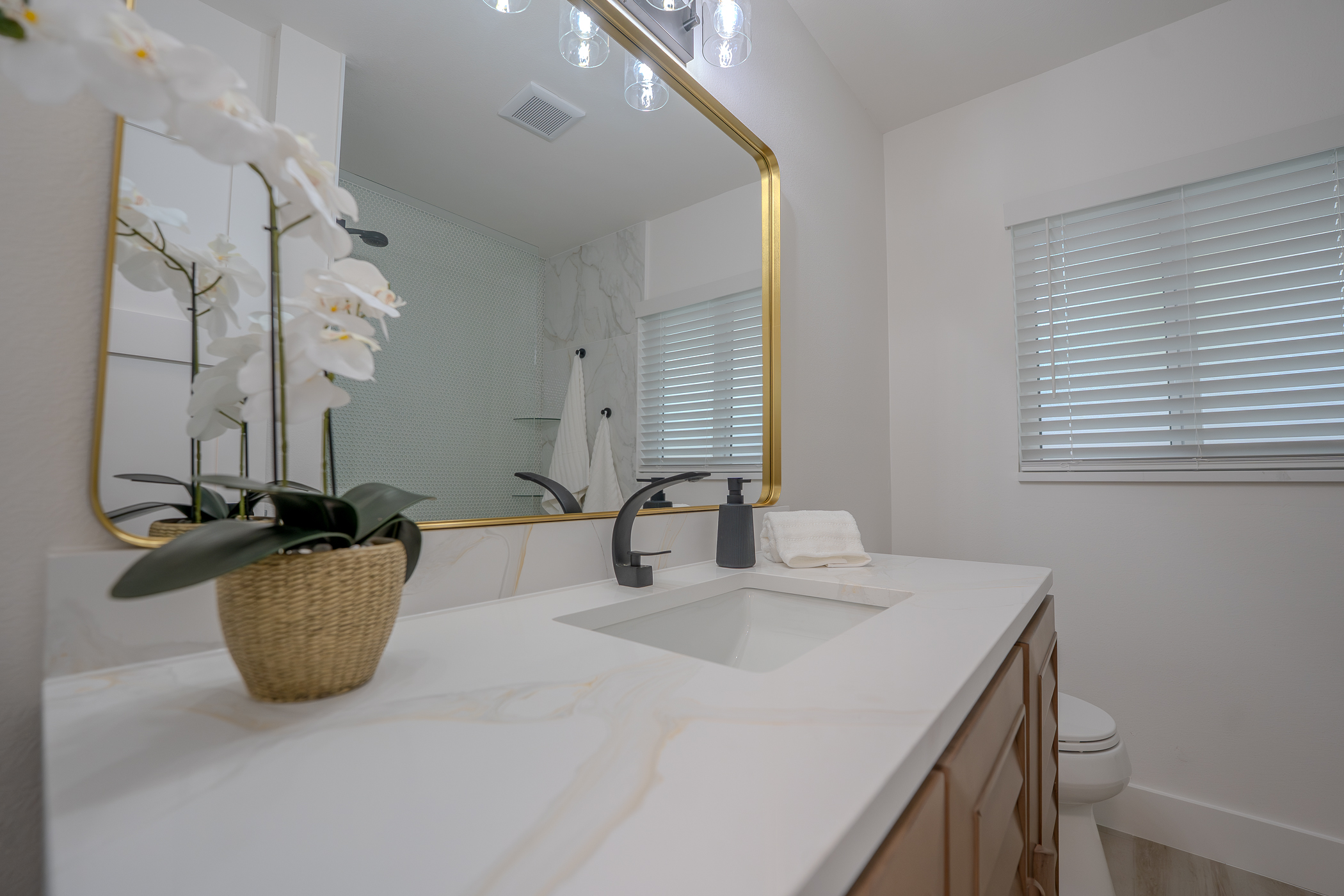 Bright refreshed bathroom with new vanity, mirror and fixtures along the Florida beaches