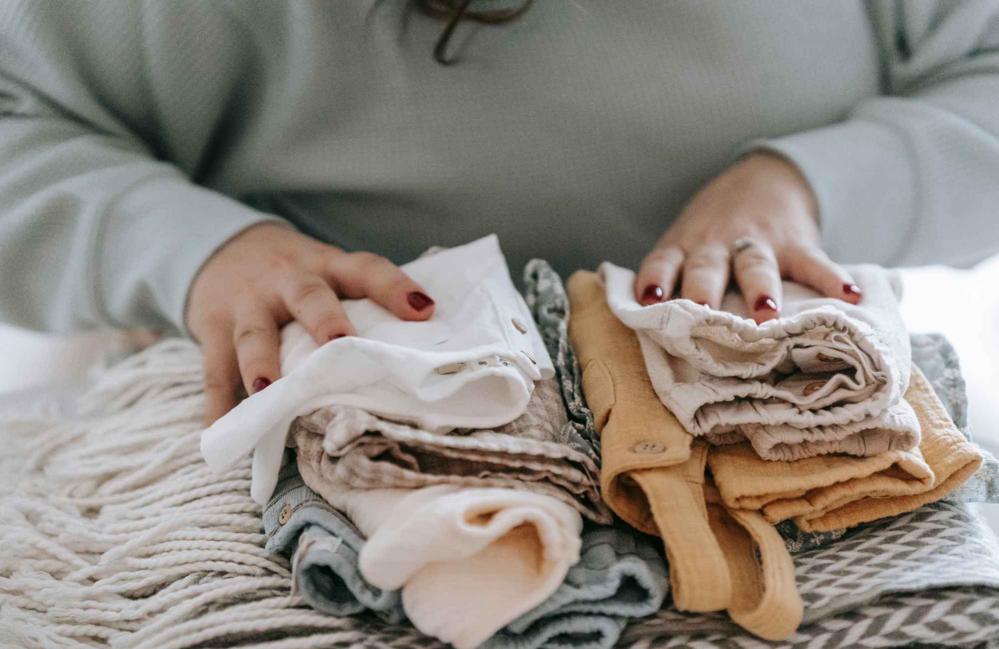 organized-by-keli-&-co-cherry-creek-co-letting-go-of-sentimental-items-woman-with-folded-baby-clothing-chanel-transform-unpacking-and-organizing