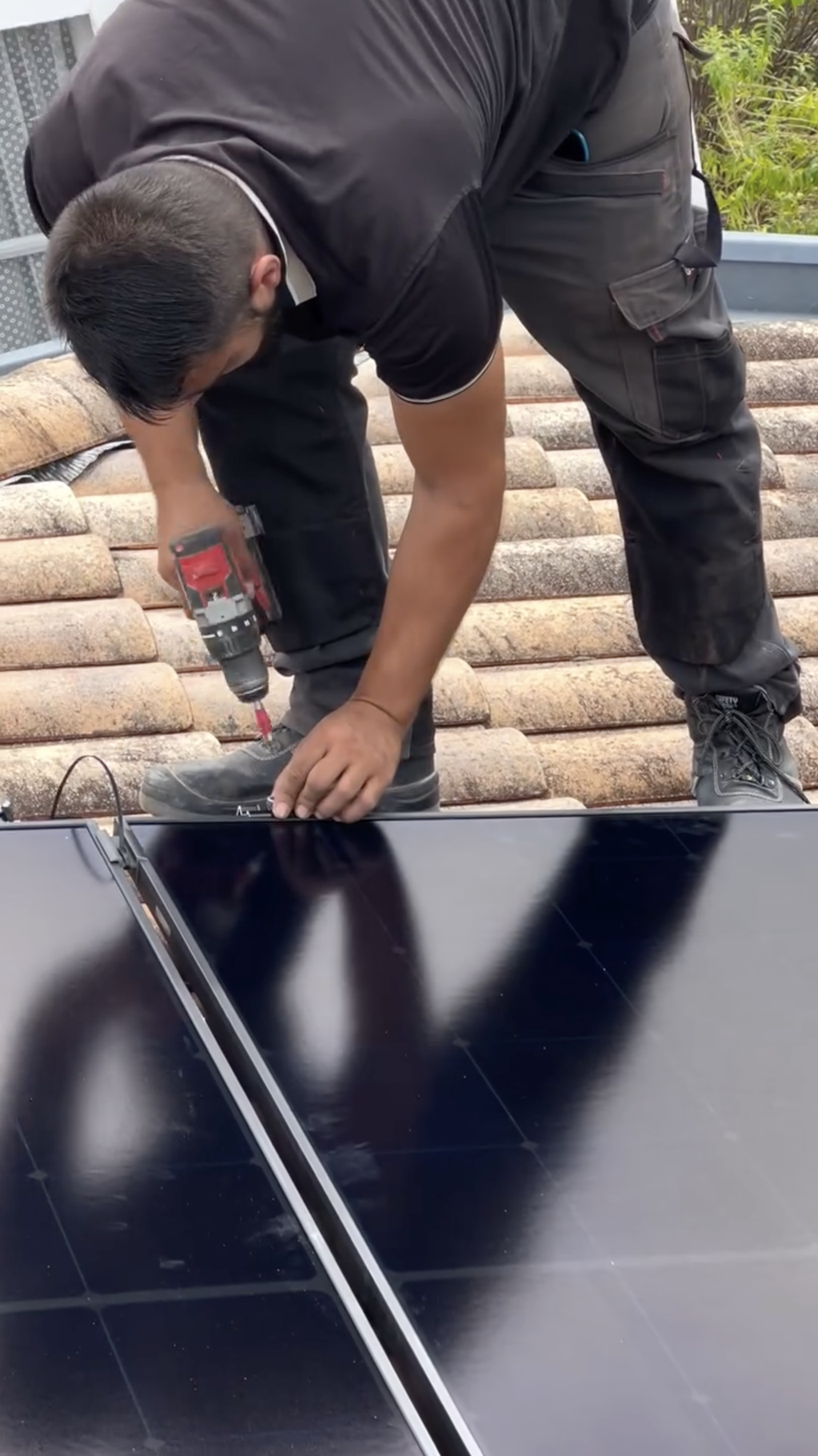 Technicien TSD Energy fixant des panneaux solaires sur une toiture