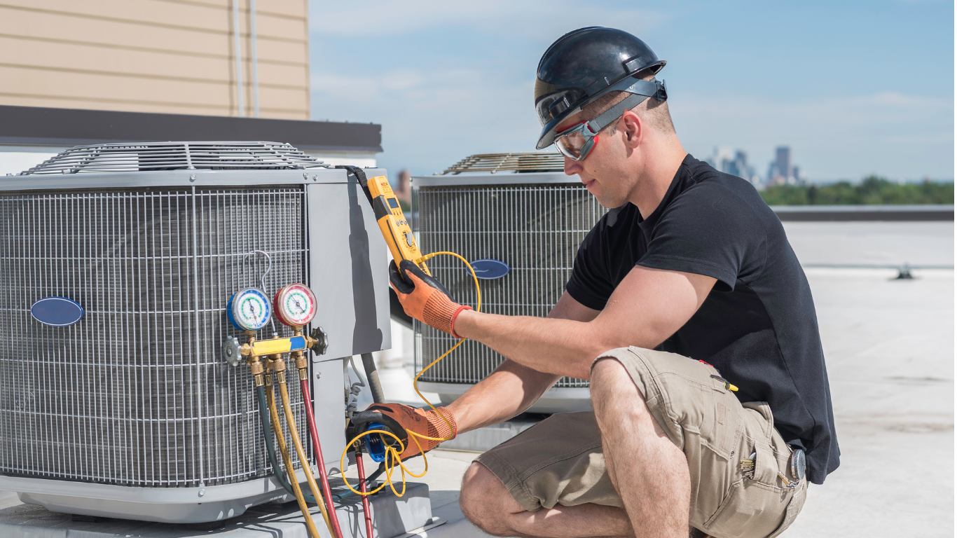 HVAC technician checking an outdoor air conditioning unit on a rooftop