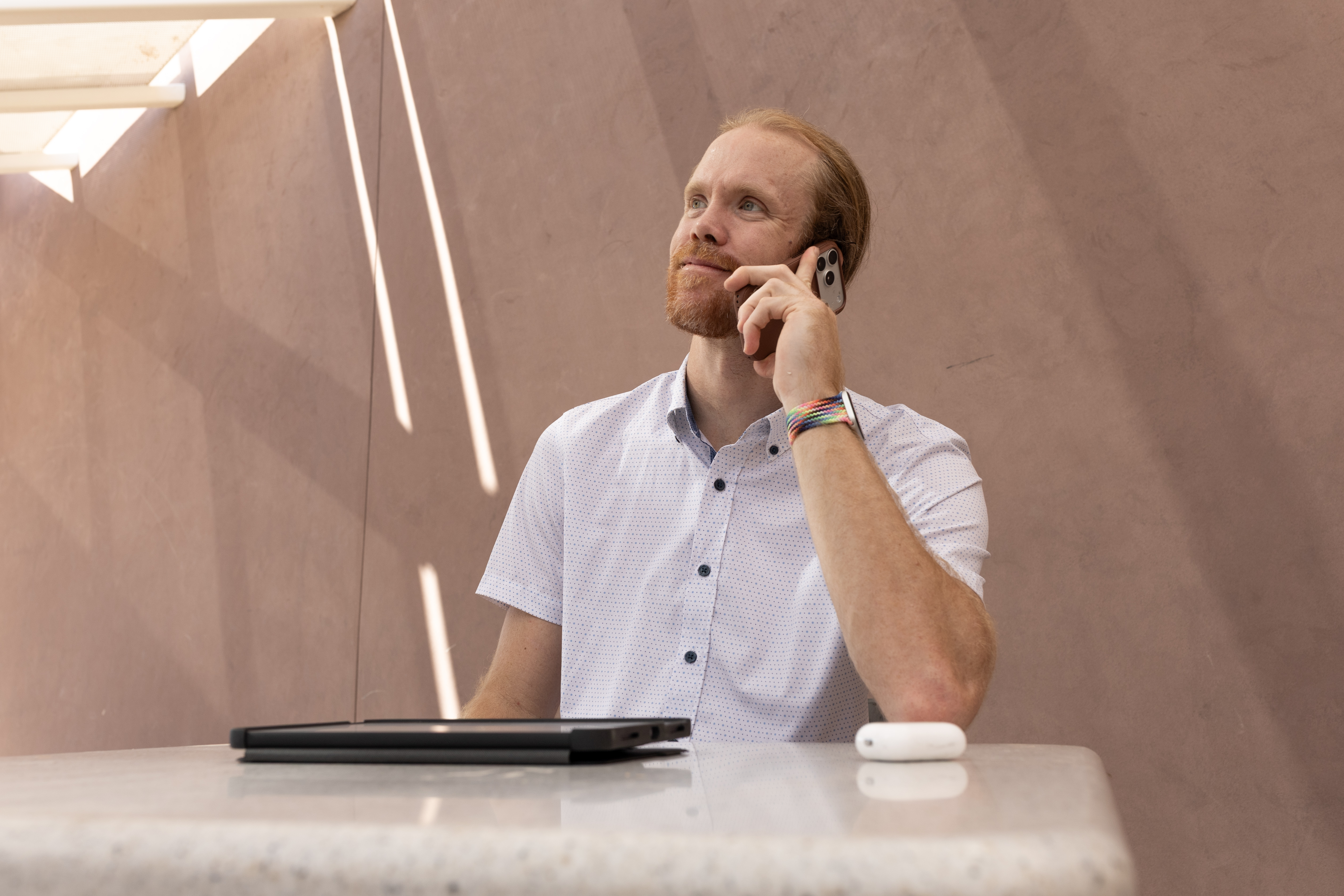 Cody Fitzgerald reviewing a client call flow on phone and laptop, Phoenix