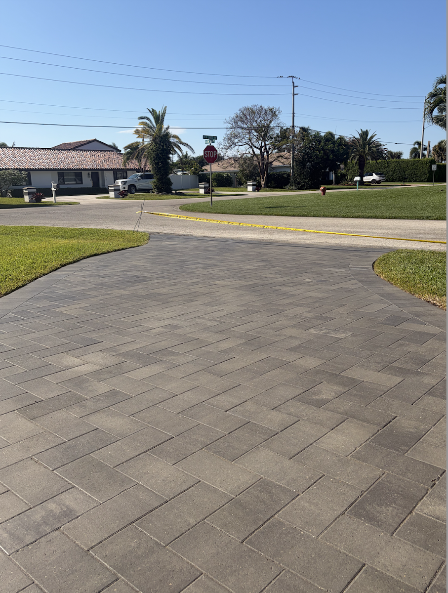 Clean herringbone paver driveway meeting a residential street