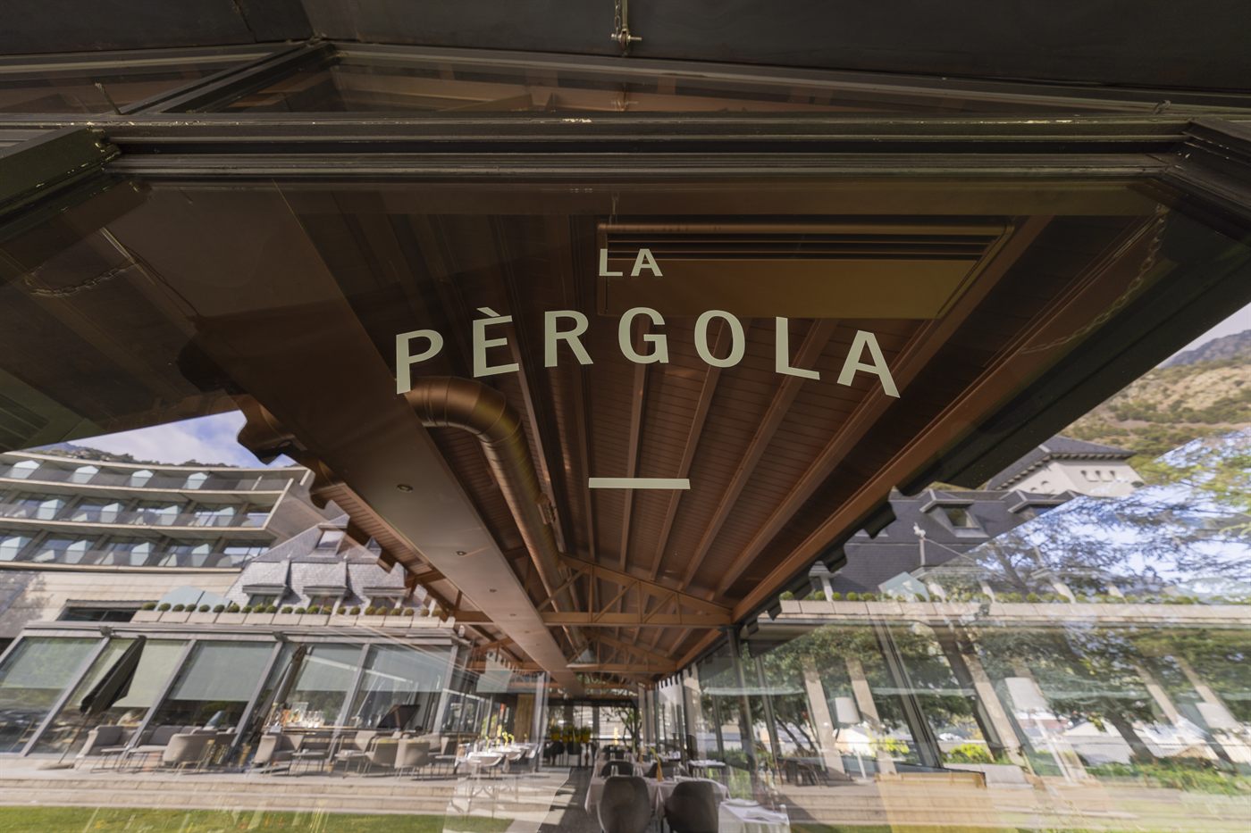 Letrero de La Pérgola en la pérgola de cristal sobre los jardines