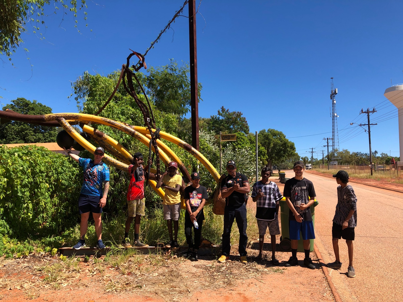 Group posing in front of yellow sculpture