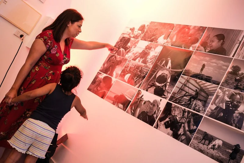 Woman and child pointing at photos