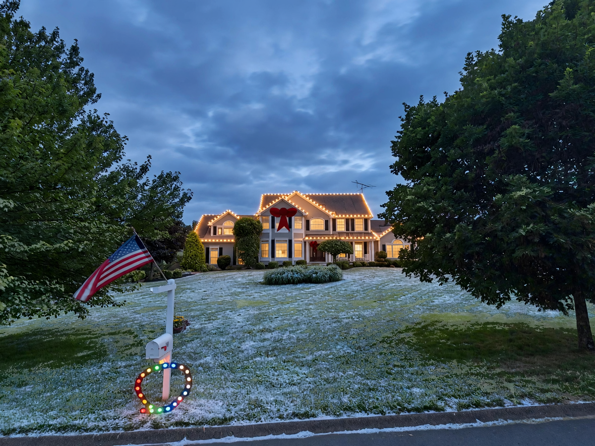 Festive home entrance with Christmas lights and evergreen greenery