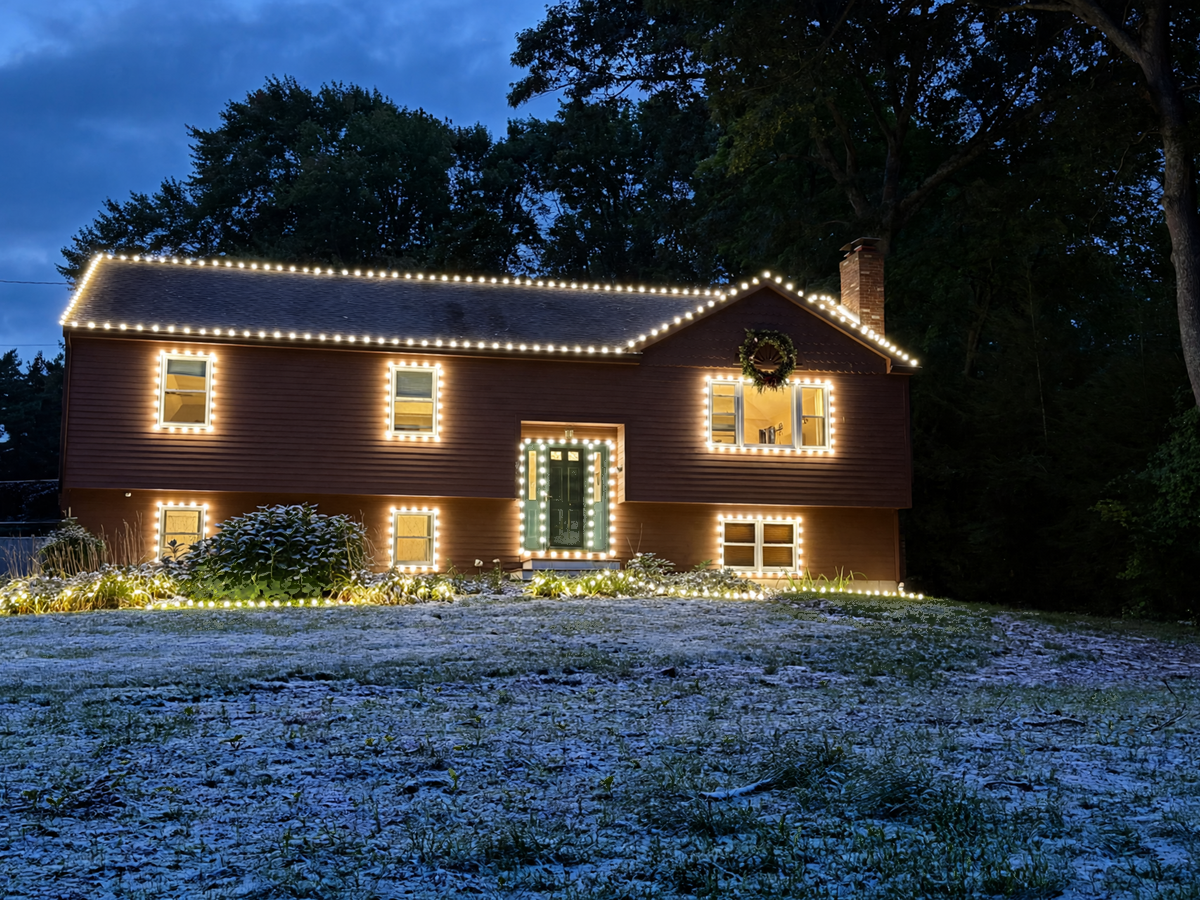 Wide view of a brightly decorated Christmas home at night