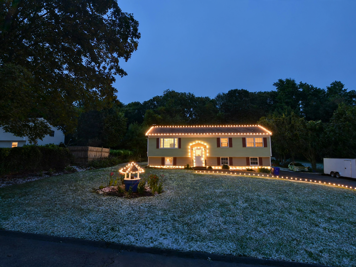 Colonial home with warm-white C9 LED roofline Christmas lights at night
