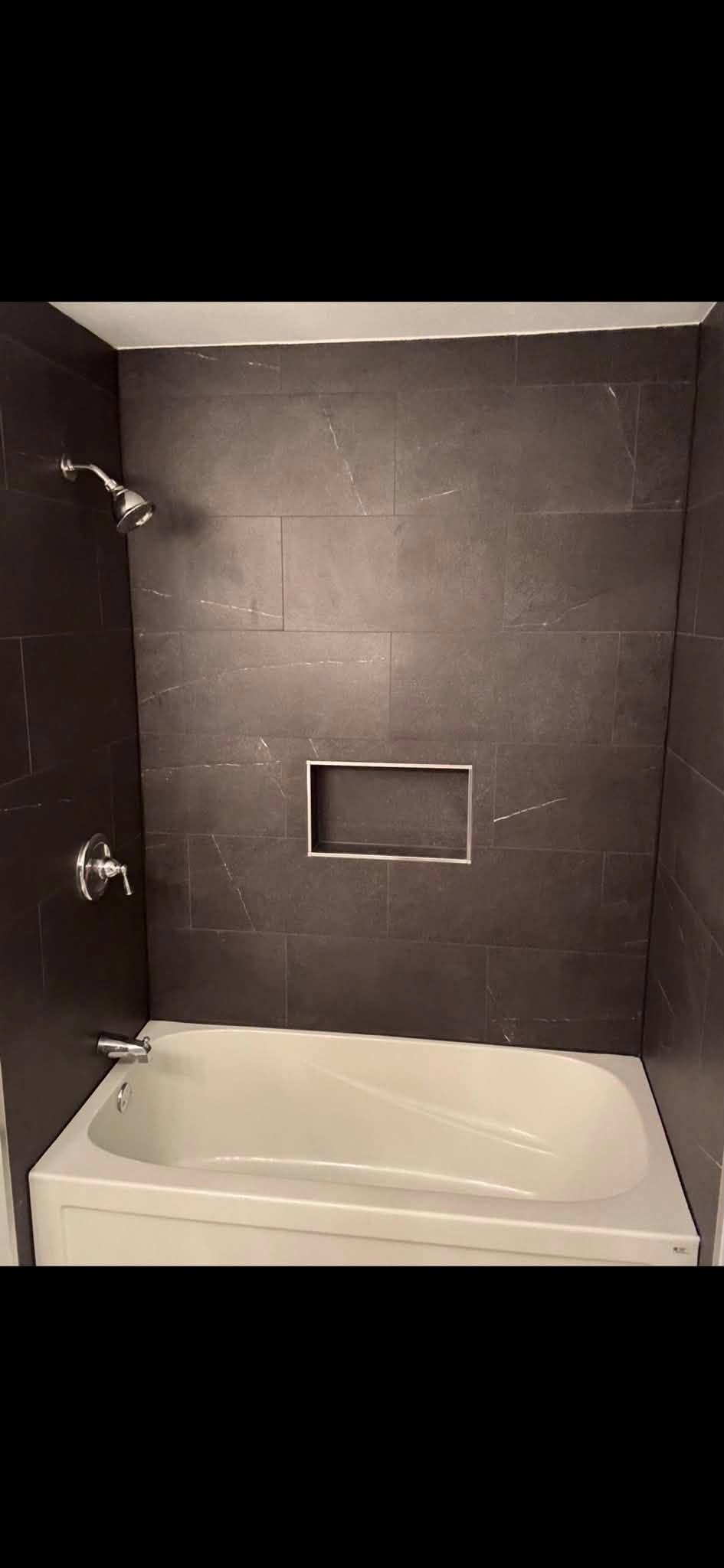 Dark tile bathtub surround renovation
