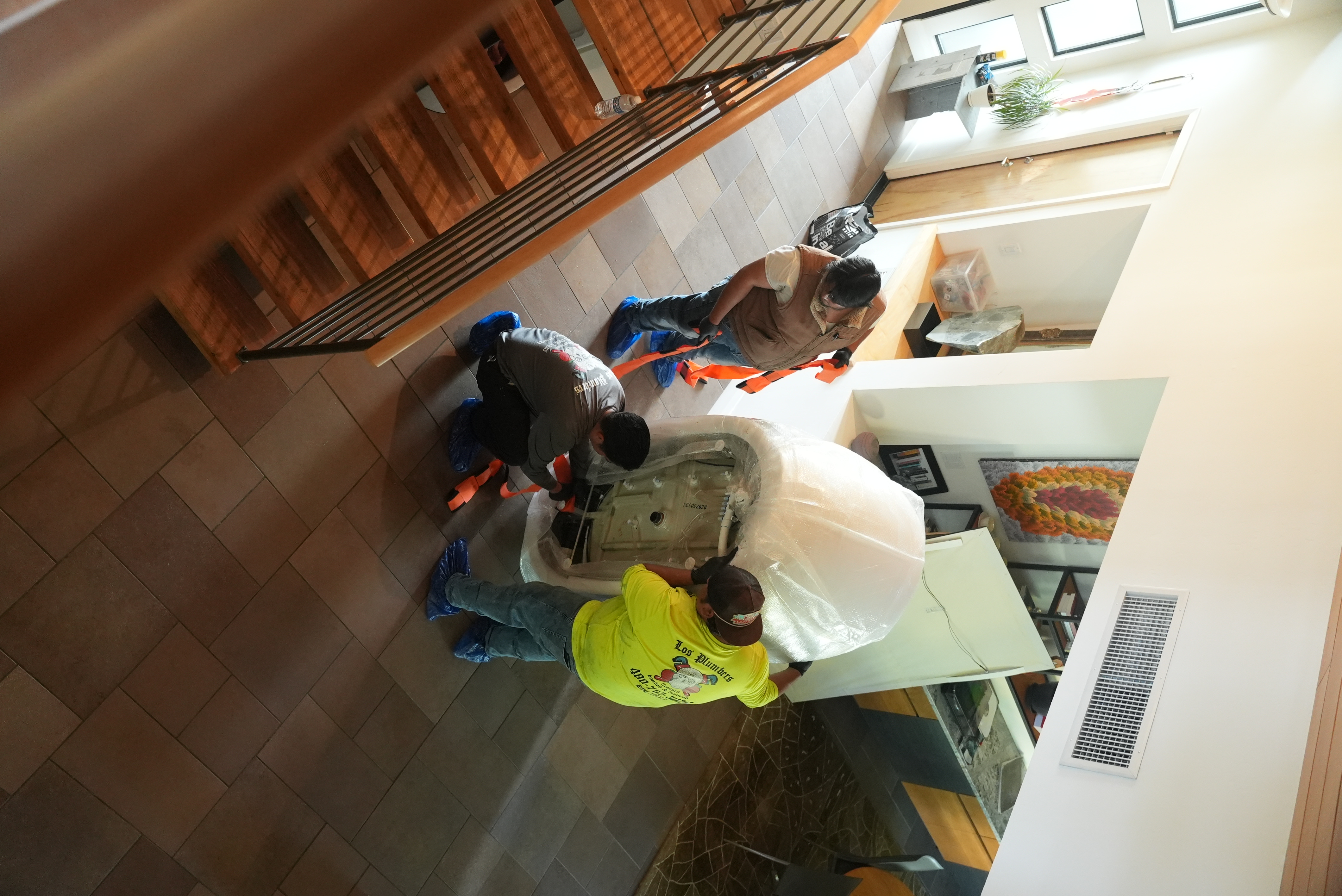 Los Plumbers workers bringing bathtub into house