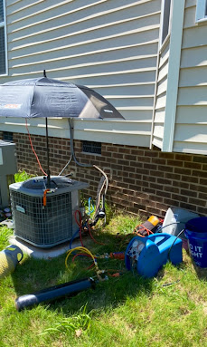 HVAC technician on ladder — commercial heating and air installation Monroe NC