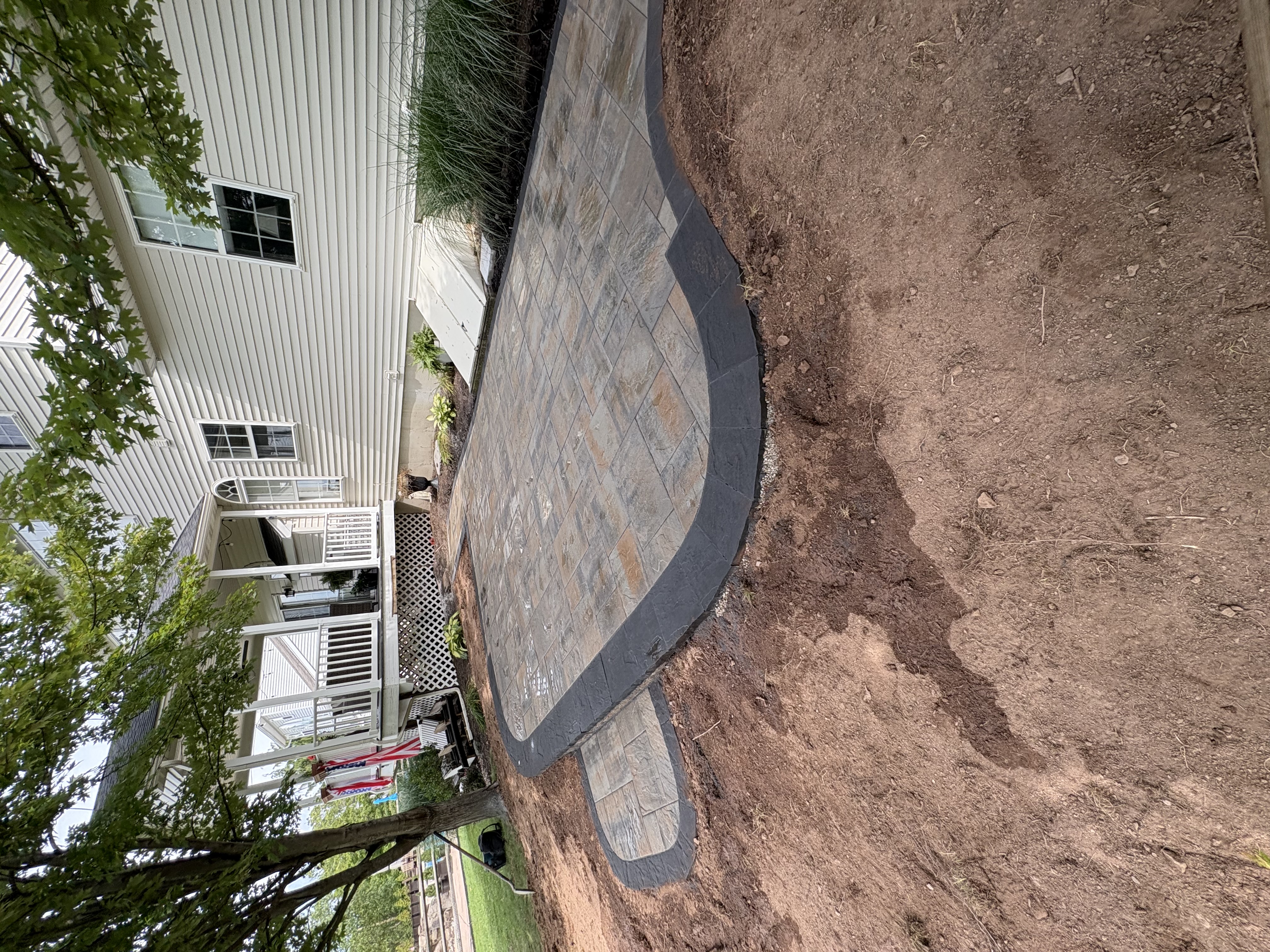 A Chester Springs residential lawn after a fall seasonal cleanup, showing cleared garden beds, trimmed shrubs, and a debris-free turf surface. Bagged organic material is staged at the curb for haul-away by the Fresh Look Landscape crew.