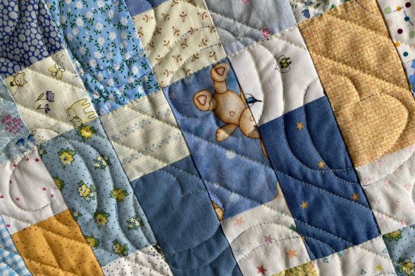 nærbilde av åpen quilting på en babyquilt. rette linjer og hjerter