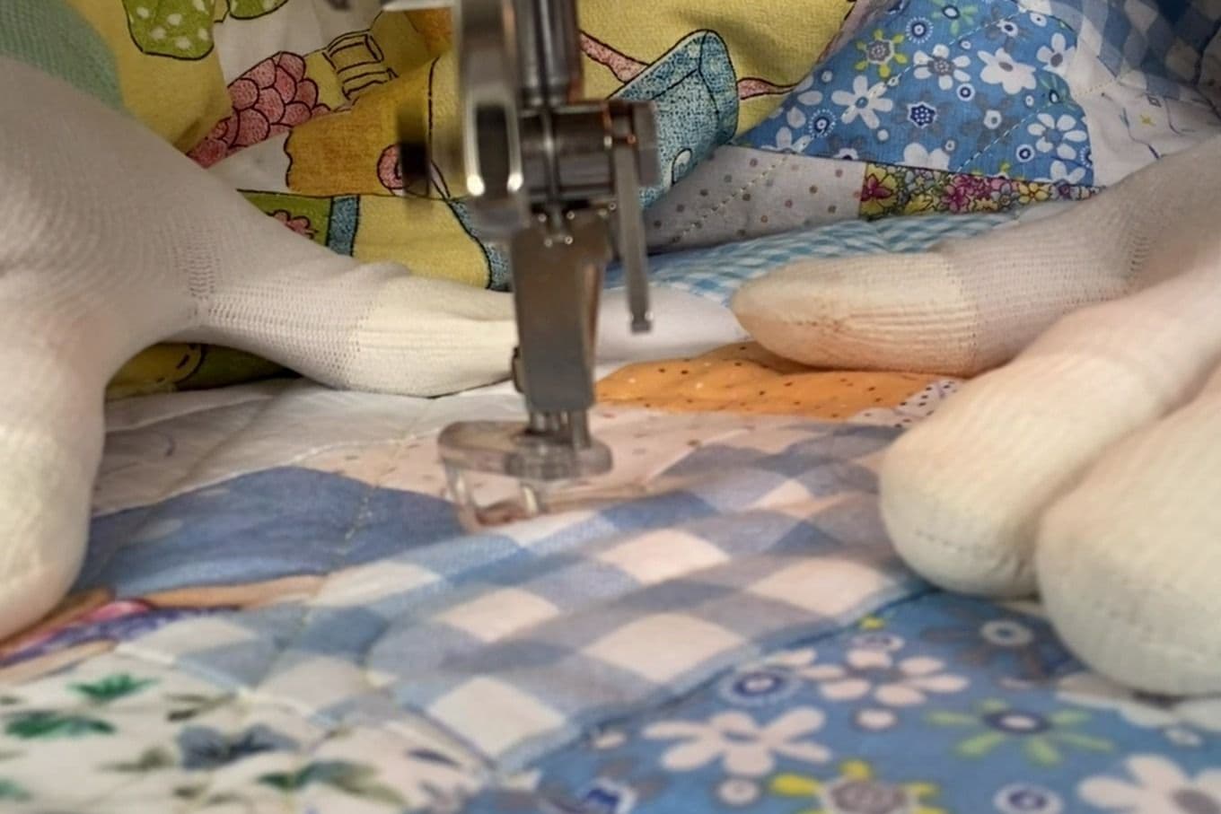 Nærbilde av quilting. Hendene danner en trekant rundt nålen
