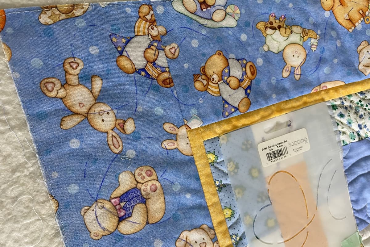 Nærbilde av hjørnet av en quilt. Det er tegnet opp et hjerte med en stensil for senere quilting