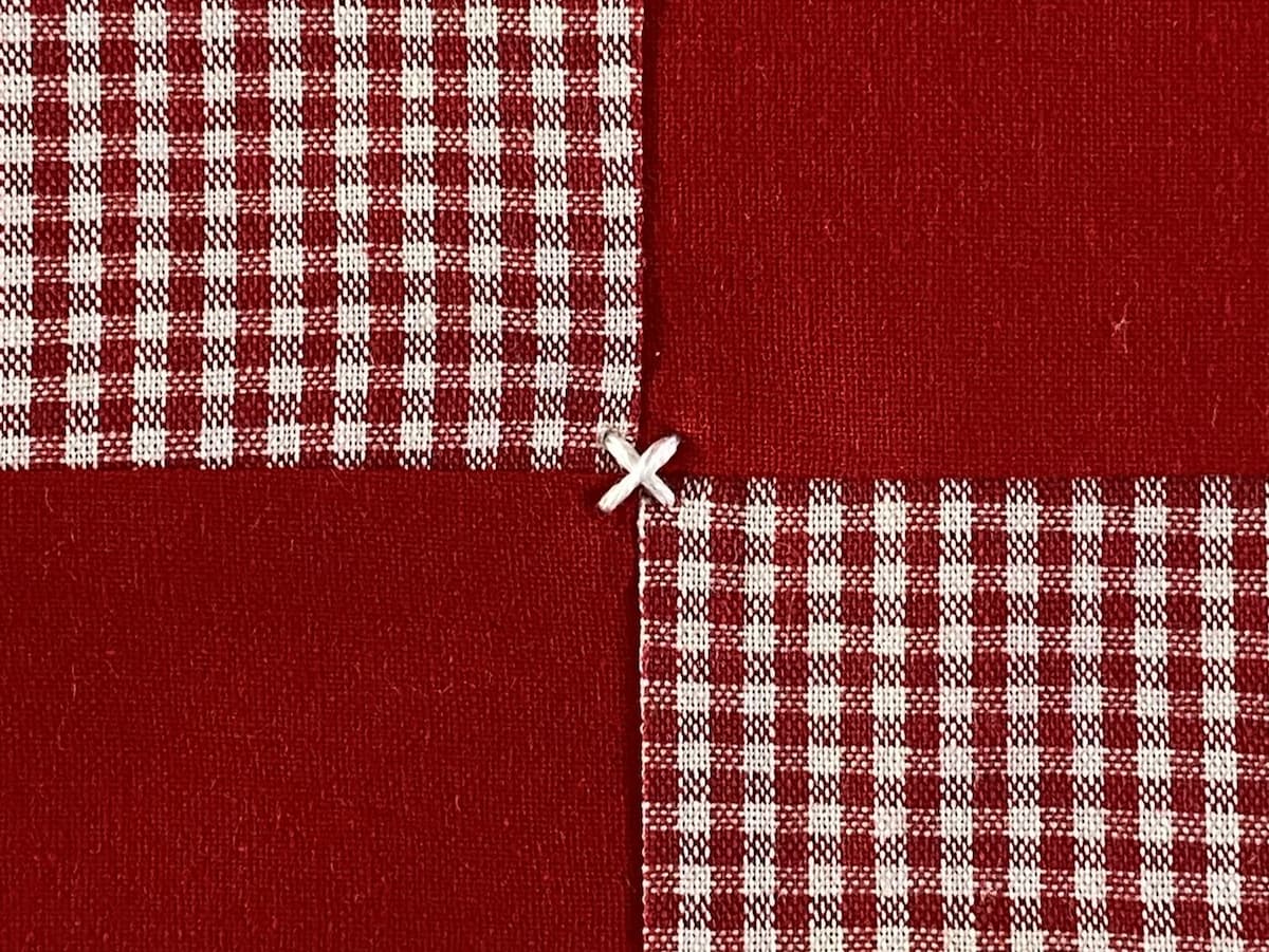 Nærbilde av en quilt som er knytet med en X på forsiden
