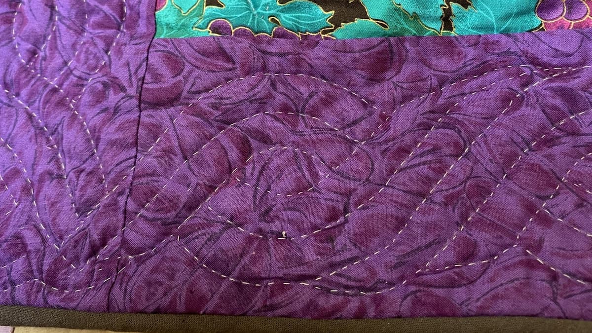 Nærbilde av borden på en quilt, håndquiltet med en kabelbord. Nærbilde av borden på en quilt, håndquiltet med en kabelbord.