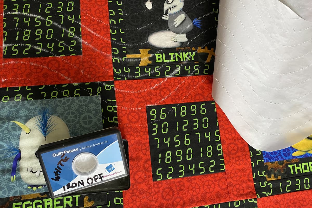 Quilttopp med design markert med pounce pad og en hjemmelaget stensil av frysepapir