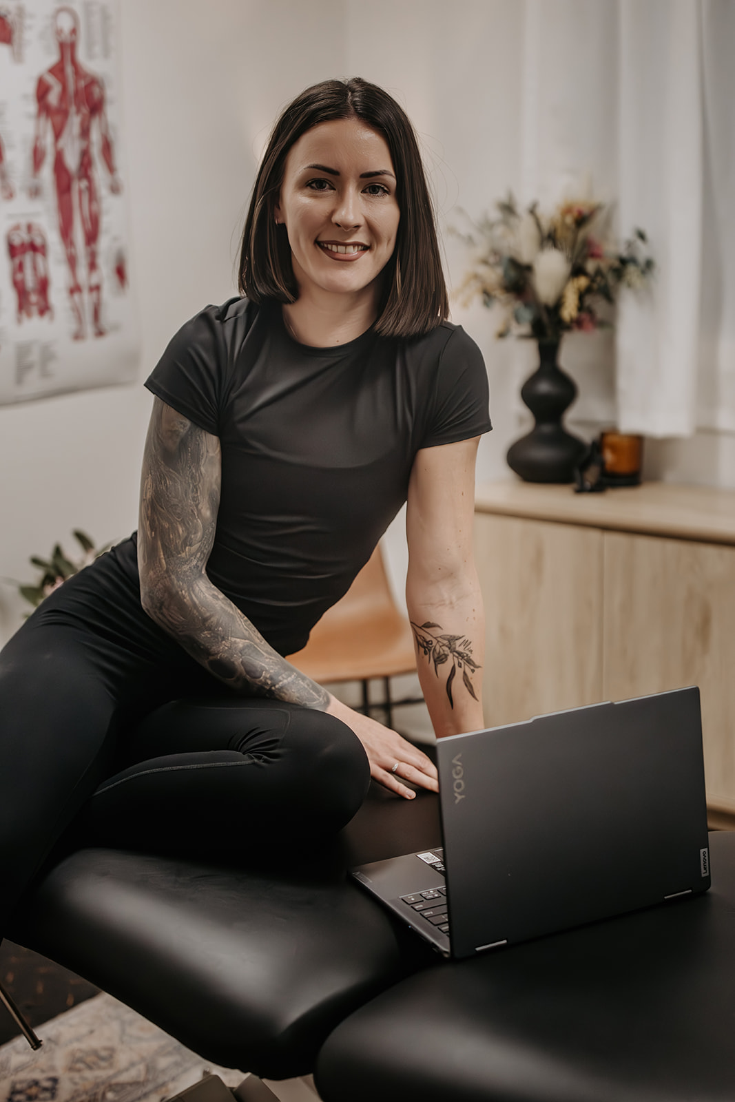 Kat in her clinic with a laptop