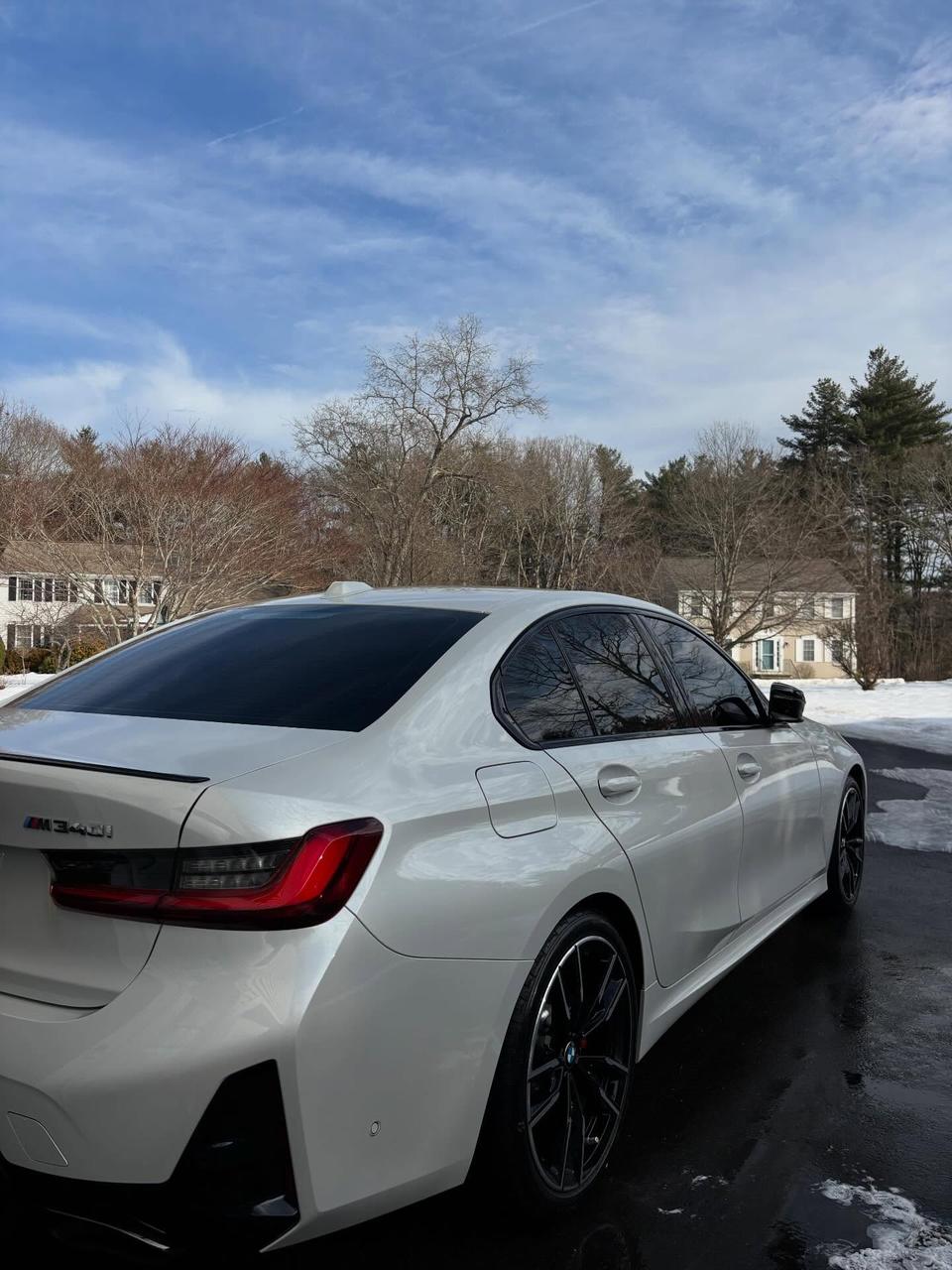 A white BMW M340i, clean with snow still on the ground