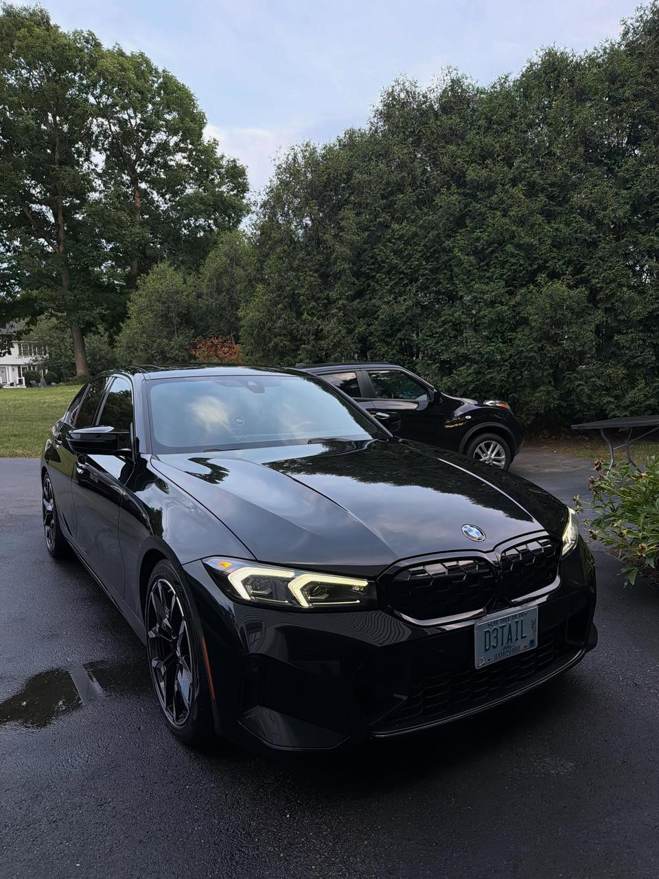A black BMW M340i with plate D3TAIL, finished and gleaming